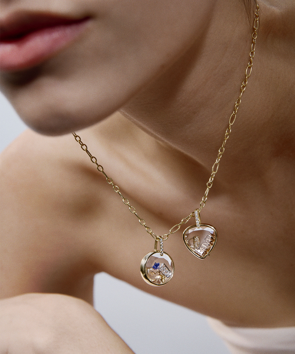 Diamond baguette set locket pendant with charms and gold chain styled on a velvet Loquet gift box against on an electric blue background
