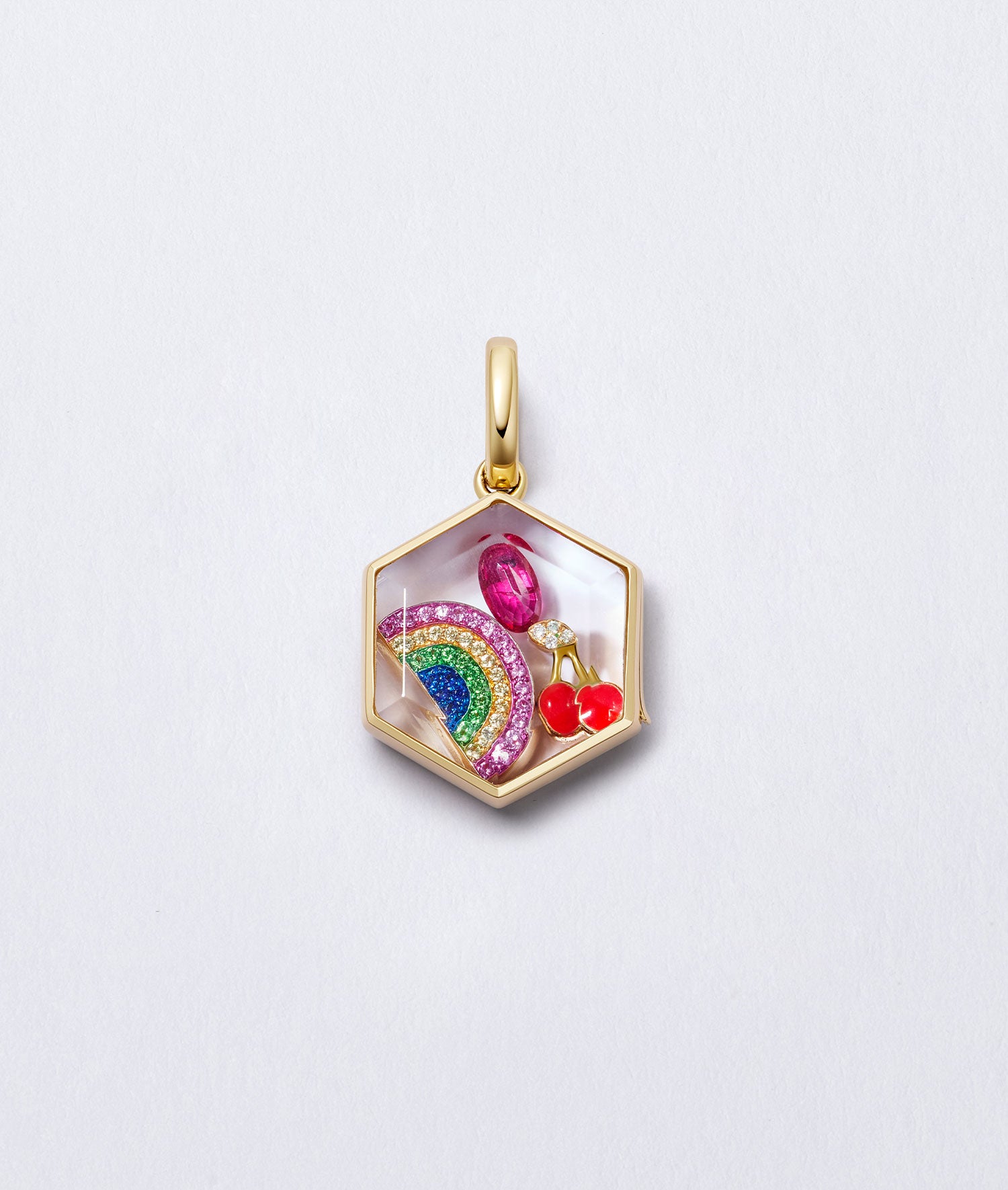 Yellow gold hexagon locket pendant styled with a rainbow, pink gemstone, and cherry charms inside on a light background.