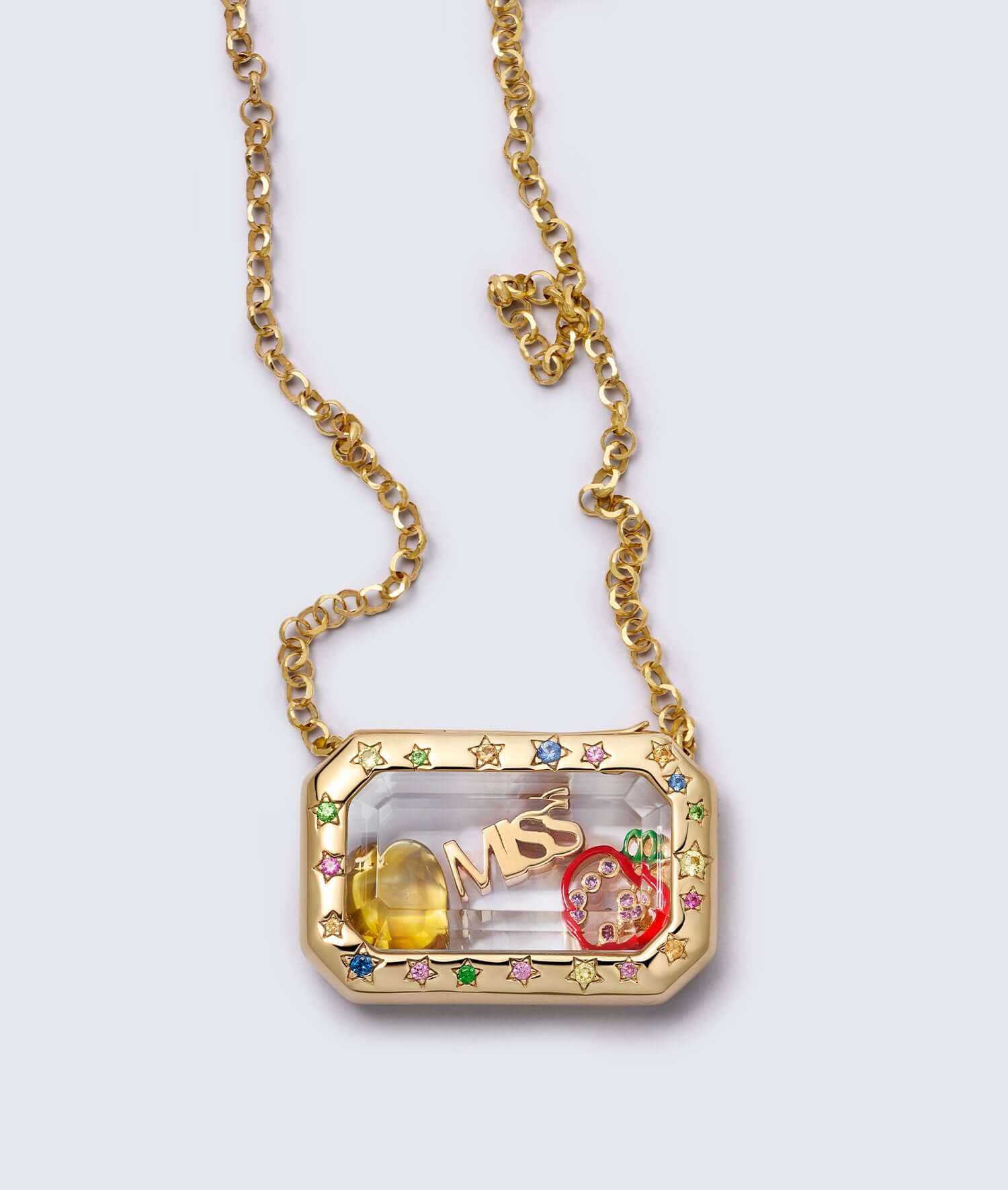 Elegant gold necklace featuring a rectangular charm locket pendant with star details, colourful gems, and intricate design elements including a small apple.