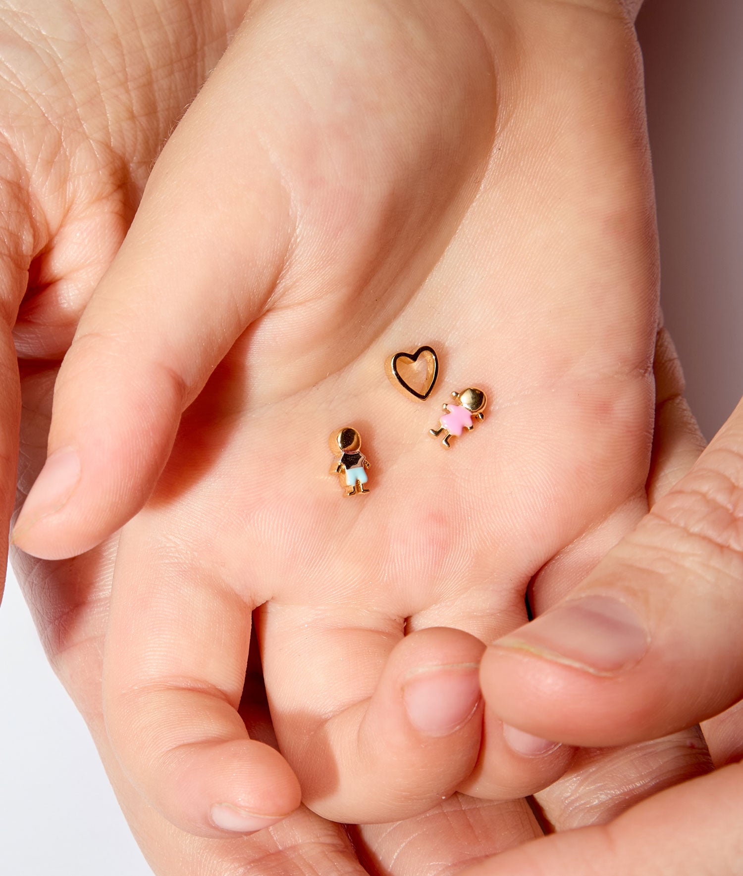 boy and girl charm styled with a heart charm in hands.