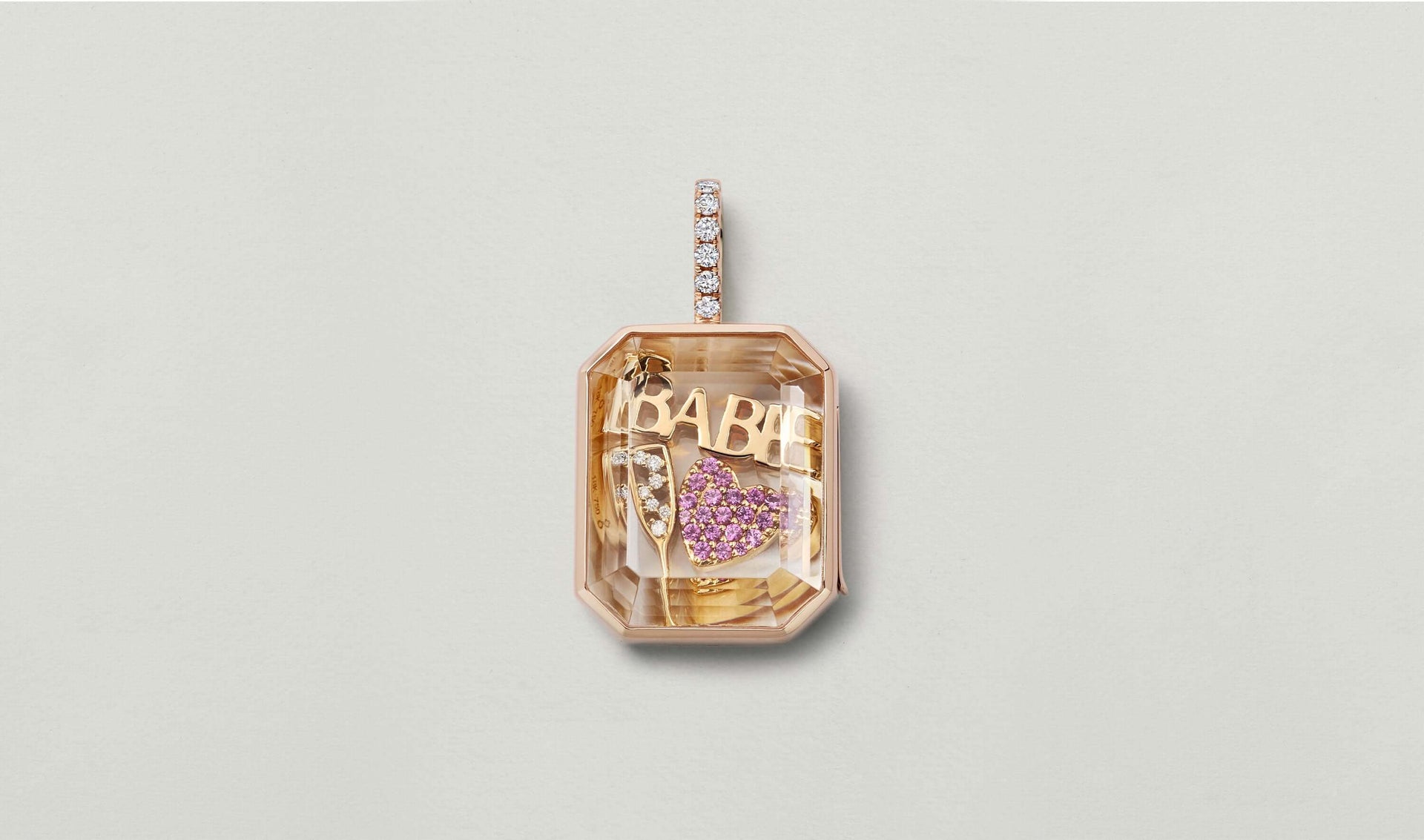 18k rose gold Babe Script Charm styled in a baguette diamond locket with other gold charms 