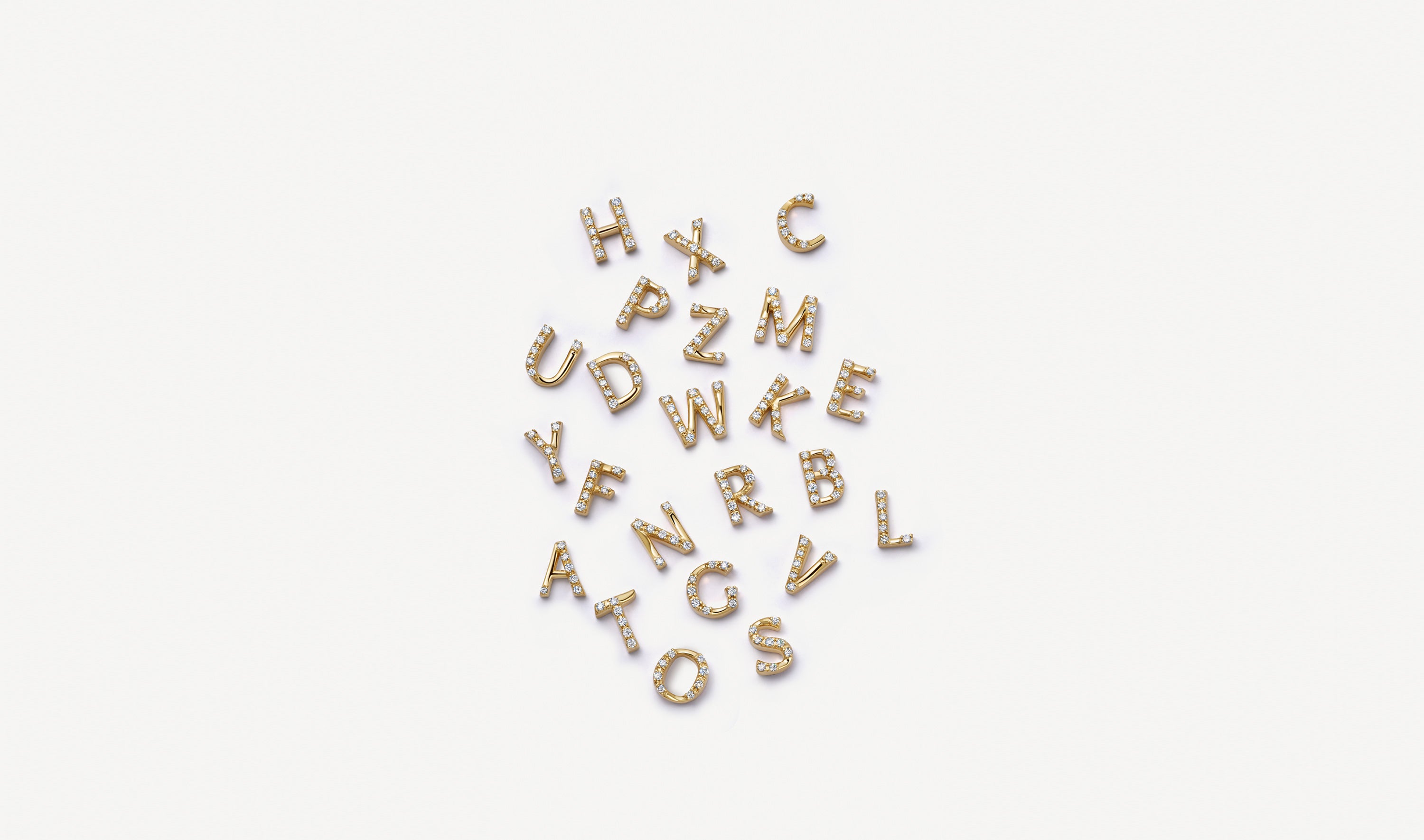 Scatter of initial letter yellow gold charms set with diamonds