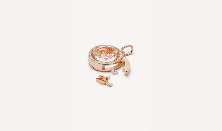 April birthstone, a diamond styled outside the open latch of a helios round diamond rose gold locket.