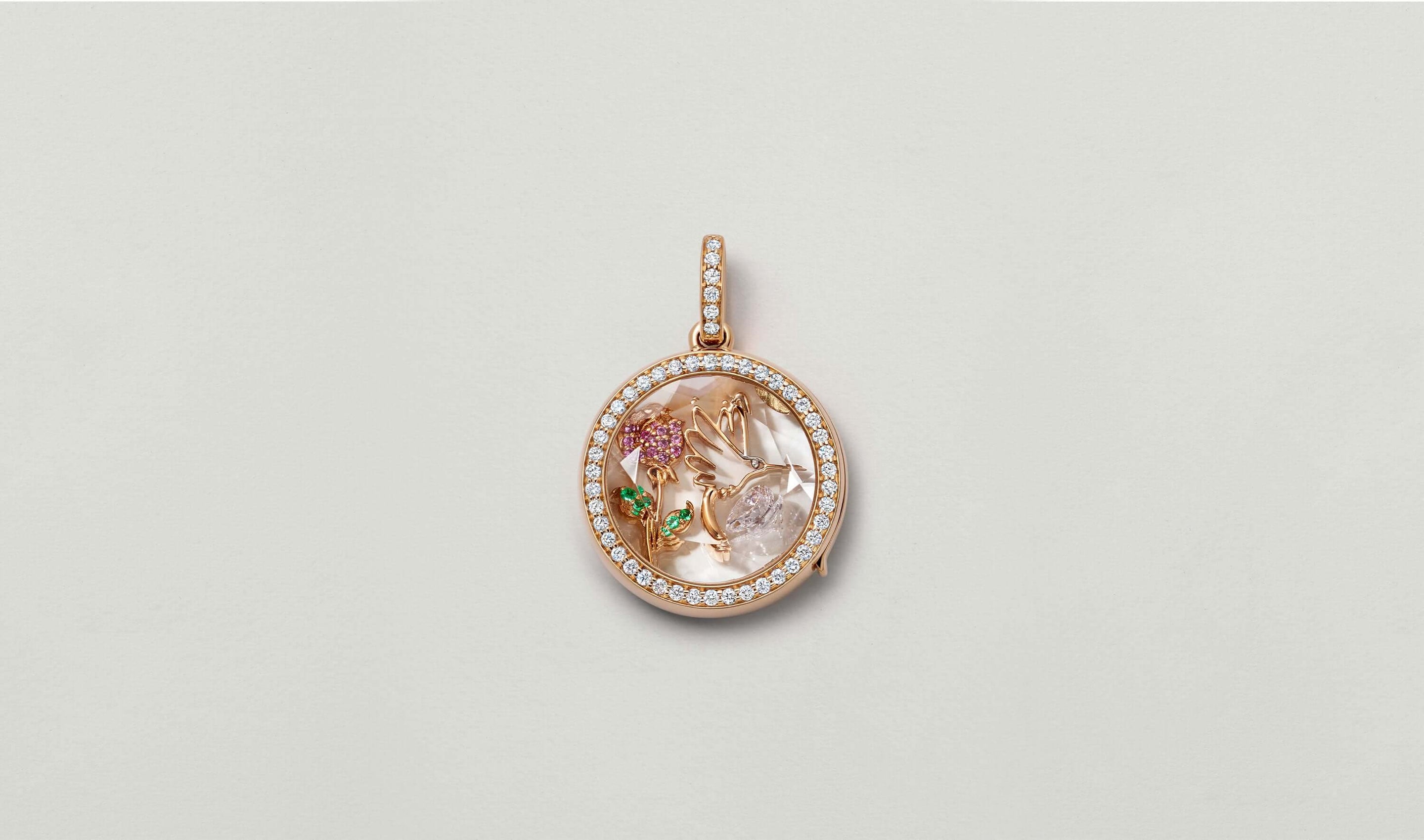 April birthstone, a diamond styled in a helios round diamond, rose gold locket with rose charm and hummingbird charm.