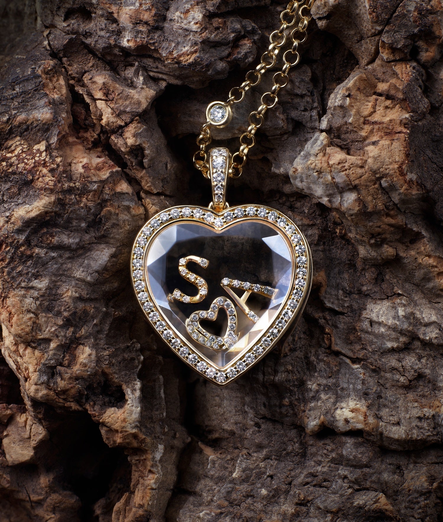 Heritage diamond heart locket on a diamond chain with letters and heart diamond charms on a bark piece