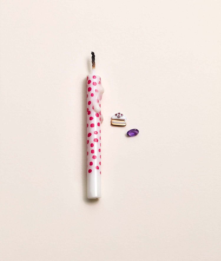 icing on the cake charm with an amethyst next to a melted candle.