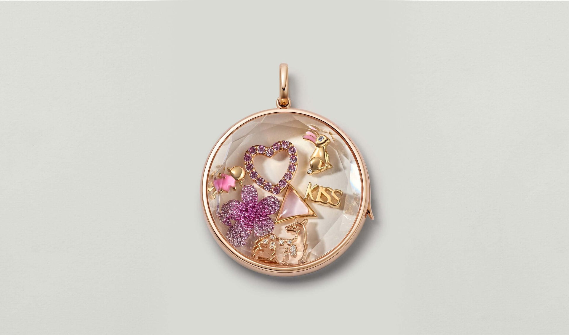 Jupiter rose gold locket styled with charms: large diamond heart charm, kiss script charm, blossom charm, rabbit charm, girl charm.