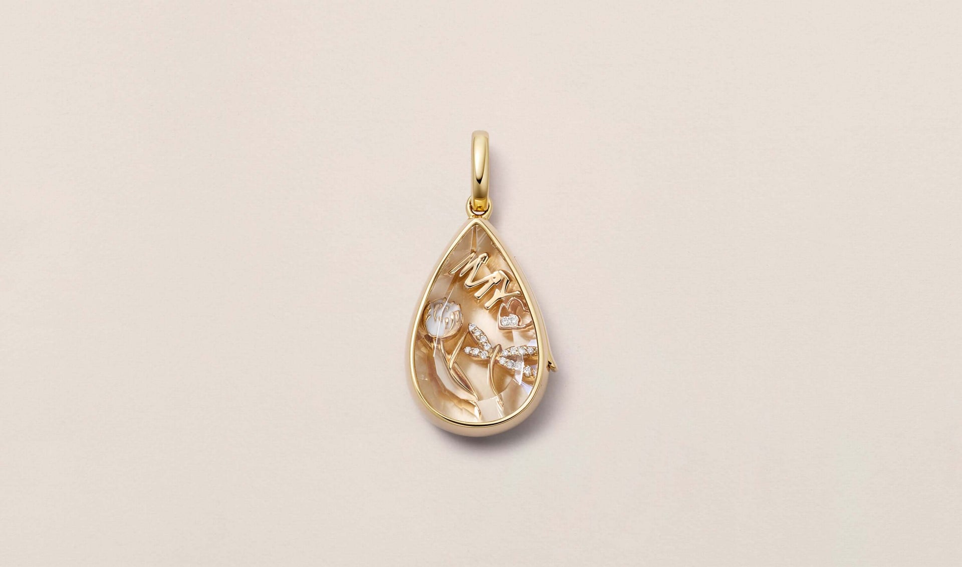 Our teardrop lacrima locket pendant styled with our My Love 18k solid gold and set with a diamond with two other charms