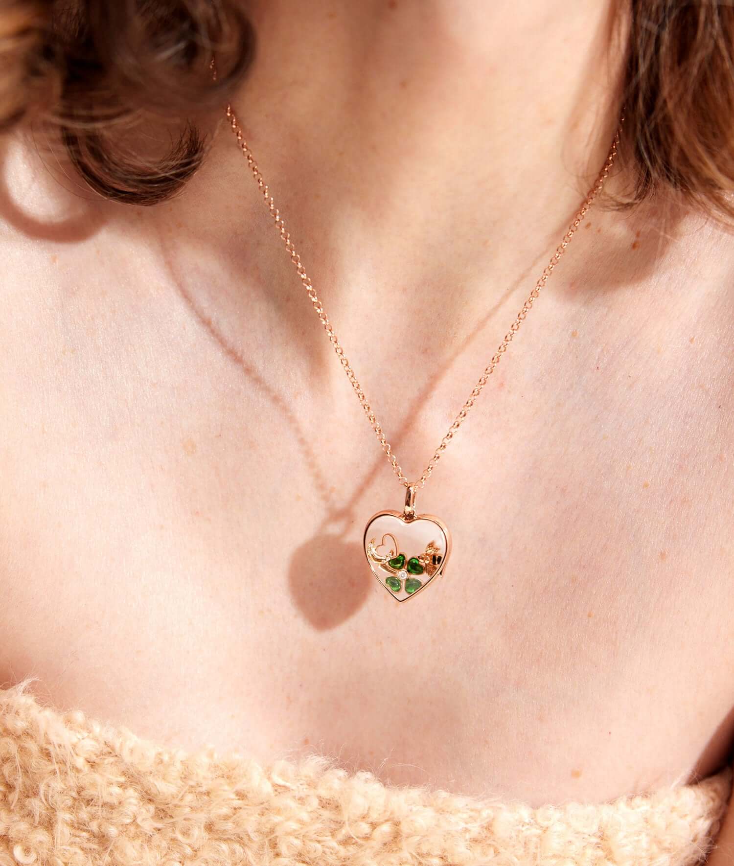 Rolo rose gold necklace 16-18 inch attached to a rose gold heart with charms.