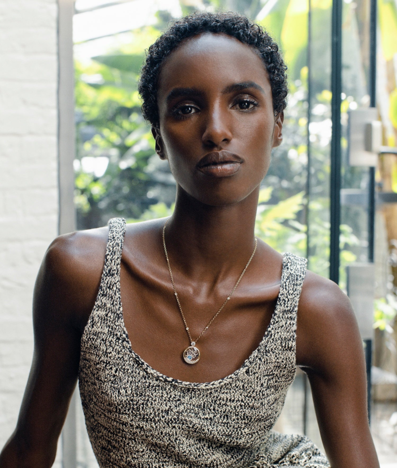Model wearing a diamond lunar cushion locket with a tank top with a natural background