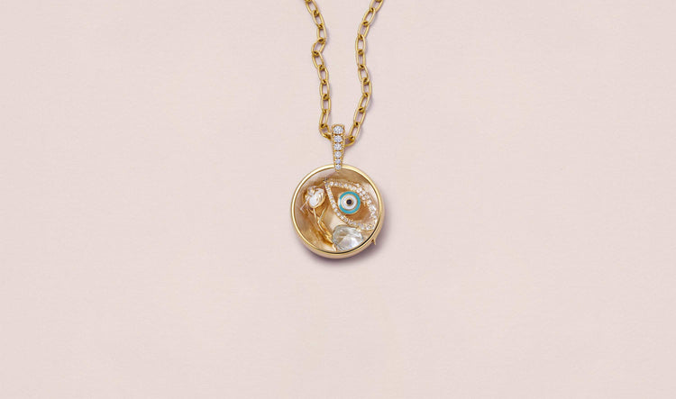 Lyra Round Diamond Gold Locket 14k  personalised with colourful solid 18k gold charms and hanging on a yellow gold chain photographed on a neutral background.