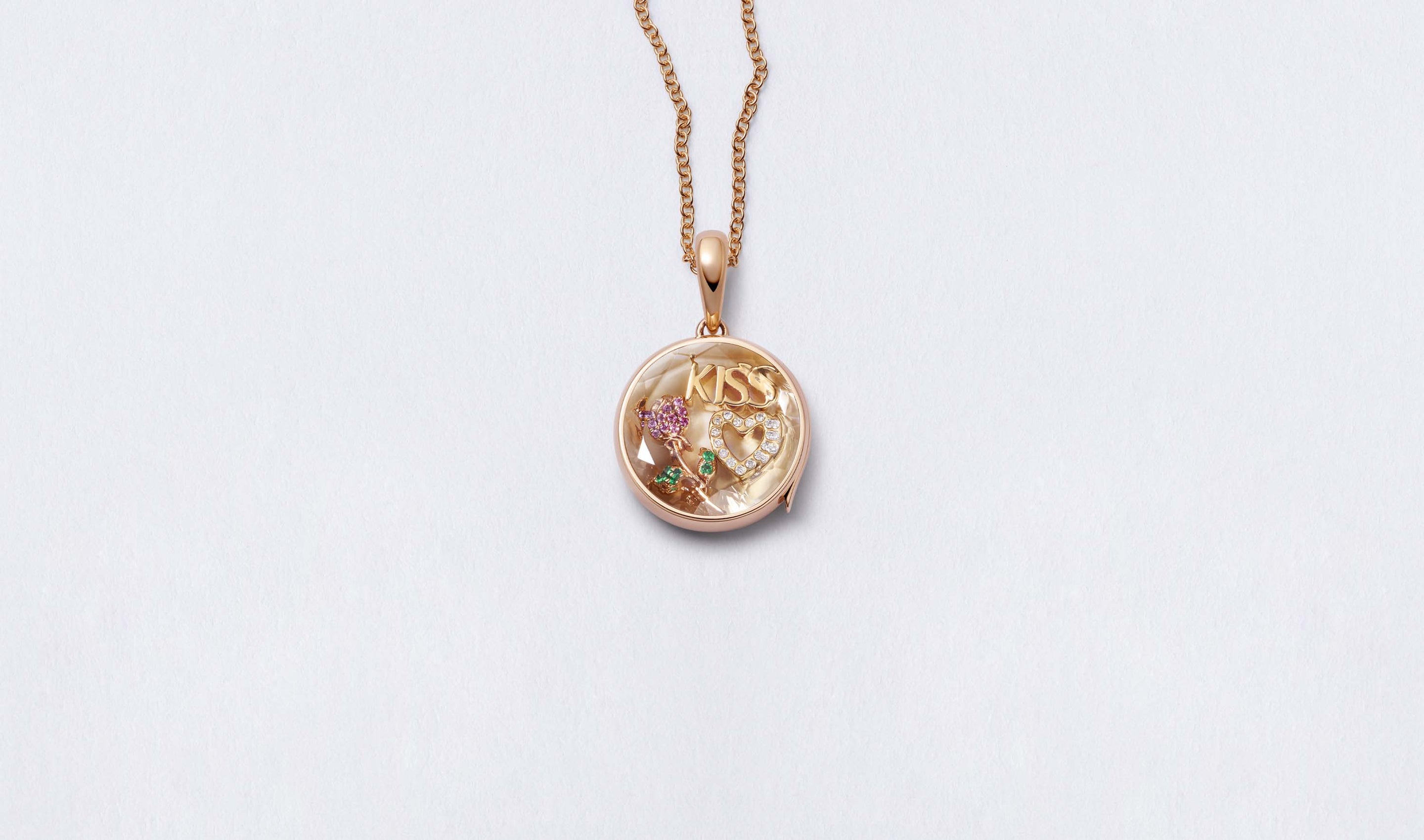 Midi Round Rose Gold Locket 14k personalised with colourful solid 18k gold charms and hanging on a rose gold chain photographed on a neutral background.