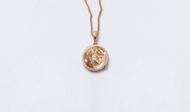 Midi Round Rose Gold Locket 14k personalised with colourful solid 18k gold charms and hanging on a rose gold chain photographed on a neutral background.