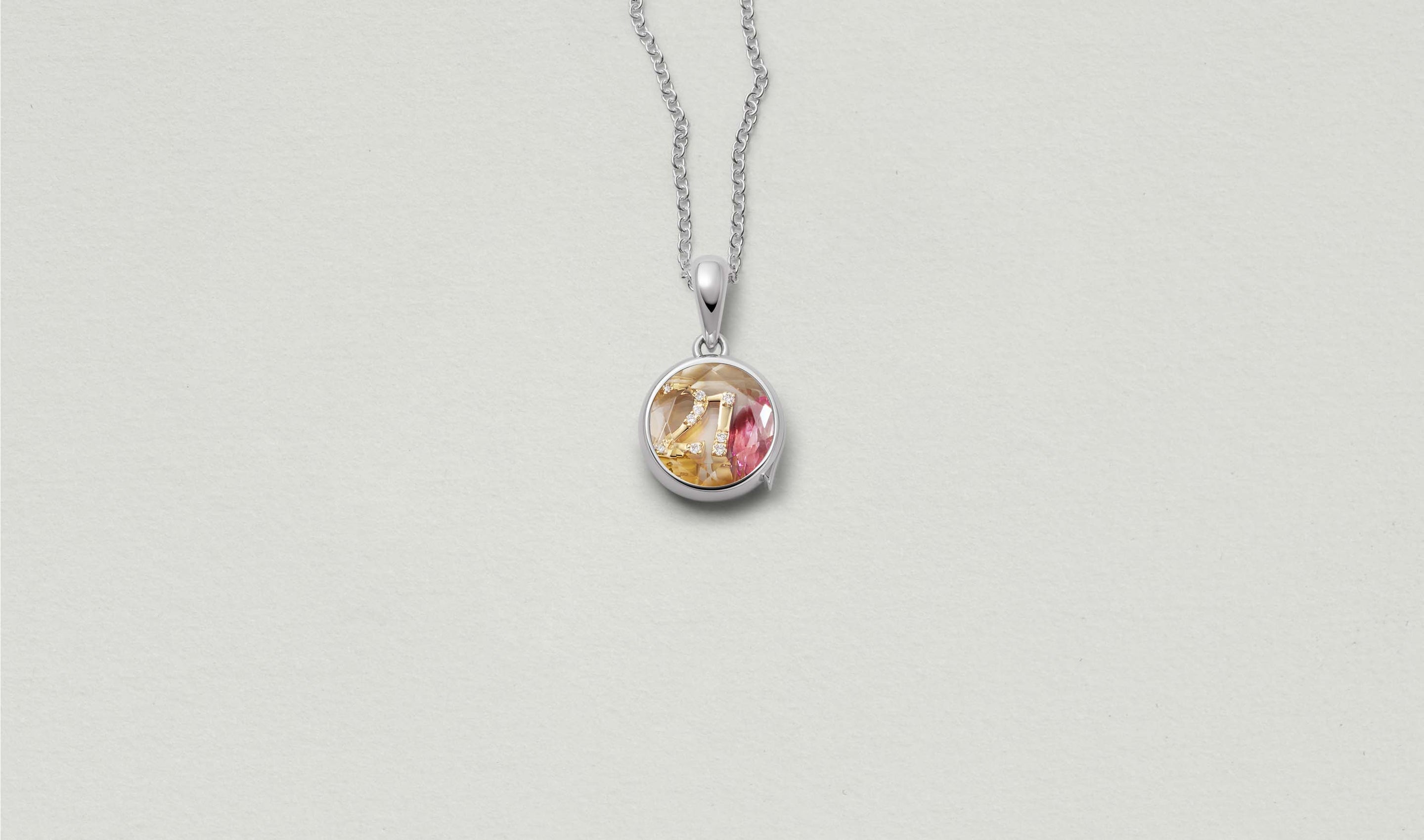 Mini Round White Gold Locket 14k  personalised with colourful solid 18k gold charms and hanging on a white gold chain photographed on a neutral background.