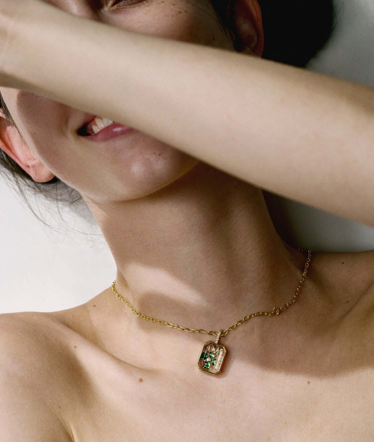 Oval 14k gold necklace on a model's neck, showcasing a delicate clip chain and pendant detail. Versatile jewelry piece.