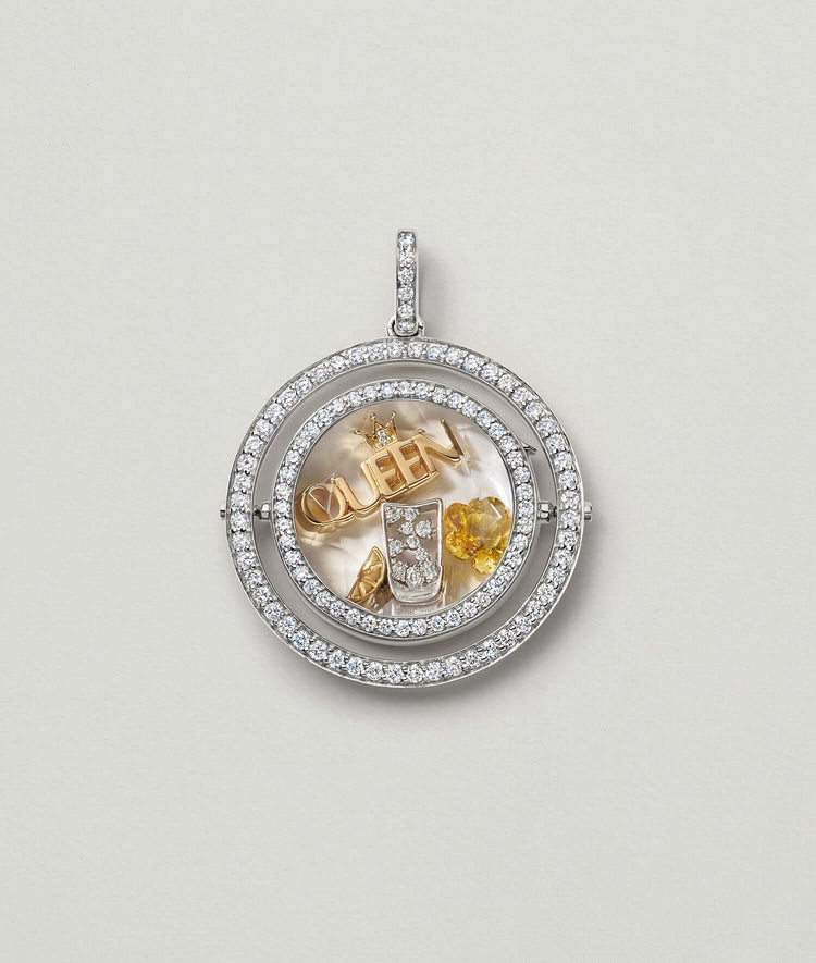 white gold saturn locket with diamonds and gold charms.