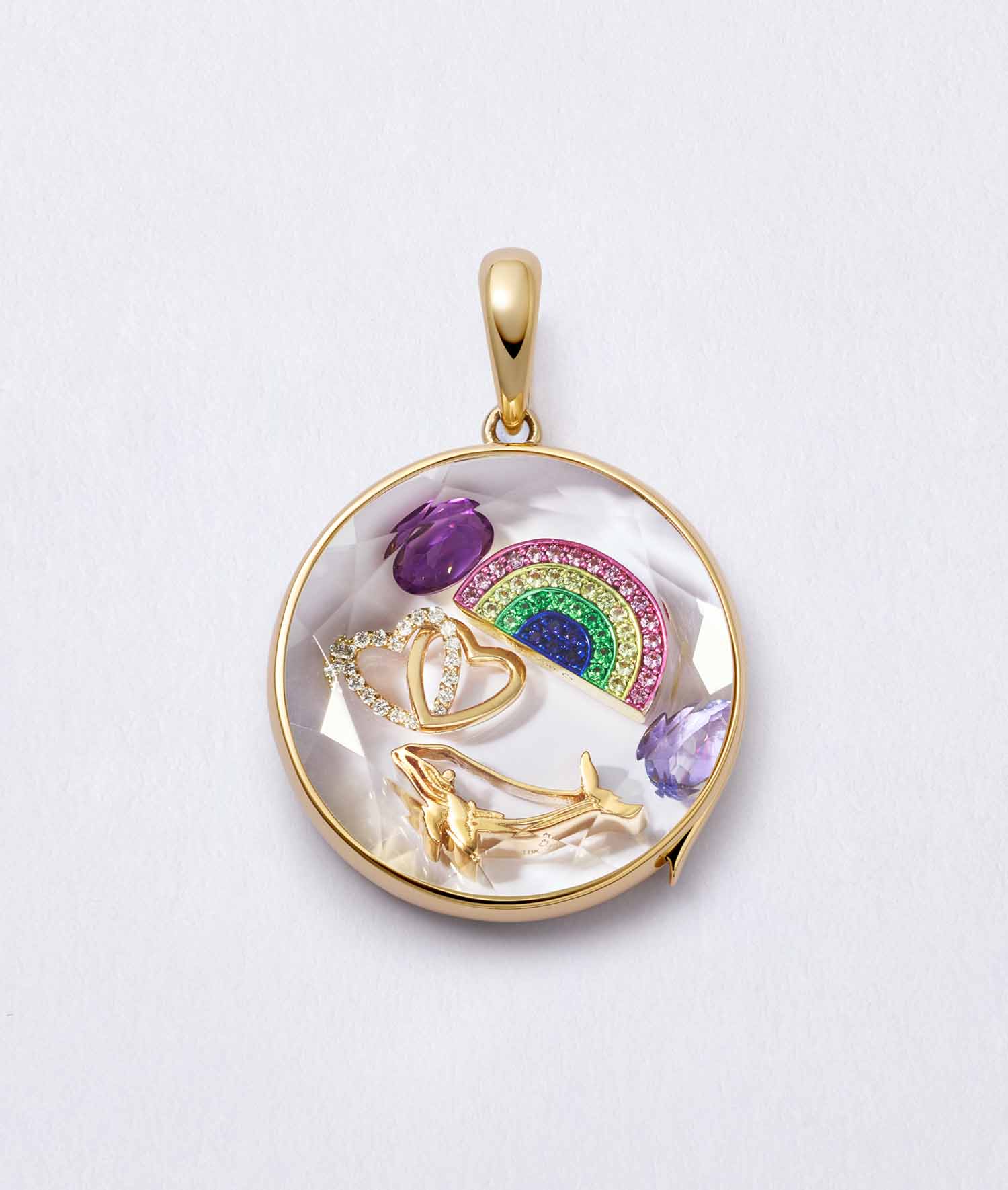 Gold whale charm in a round locket with gemstones, handcrafted in 18k yellow gold to symbolize wisdom and love.