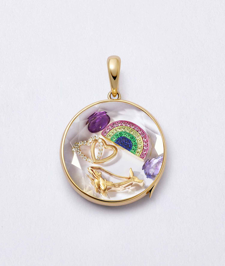 Gold whale charm in a round locket with gemstones, handcrafted in 18k yellow gold to symbolize wisdom and love.