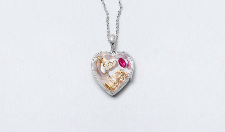 White Heart of Gold Locket 14k personalised with colourful solid 18k gold charms and hanging on a white gold chain photographed on a neutral background.