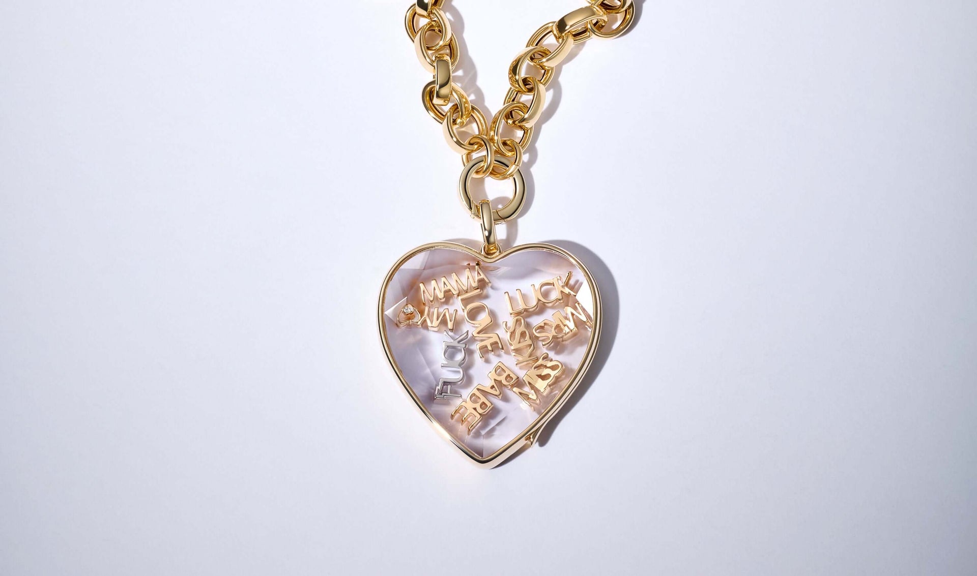 18k Yellow gold charm styled with other word charms in a large heart shape locket pendant on a chunky yellow gold chain
