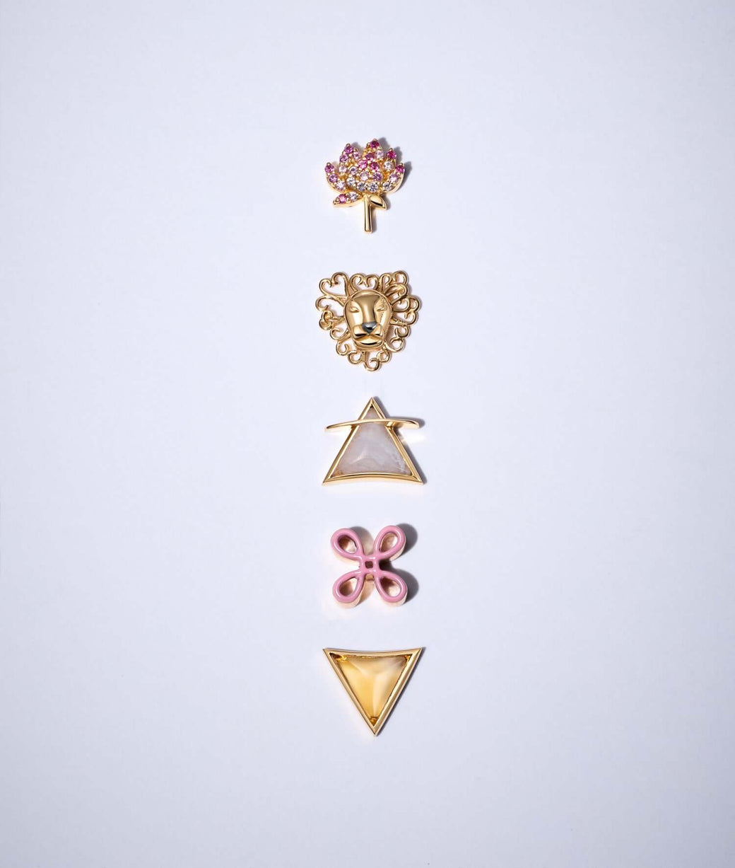 Pink bowen's knot charm, lion's heart charm, agate water charm and rose rose quartz charm on a totem like display