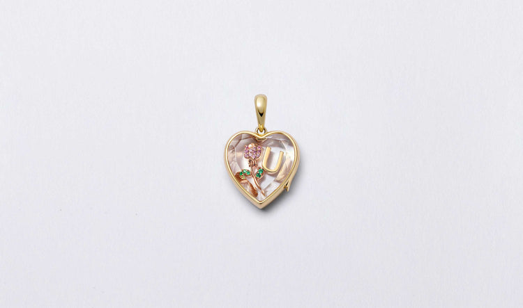 Classic heart-shaped yellow gold locket with faceted crystal facade personalised with a U letter gold charm and a rose flower stone set charm.